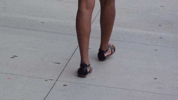 a girl walking and showing her legs