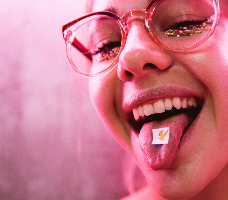 a girl taking a tab of acid